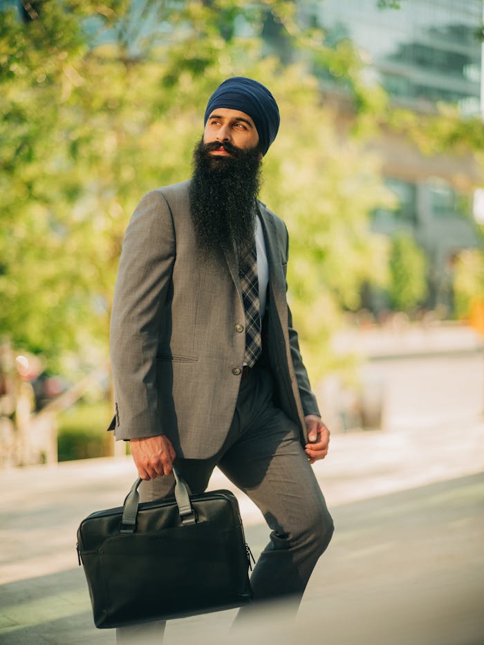 services-06 Portrait of a turbaned businessman walking confidently in a modern cityscape.