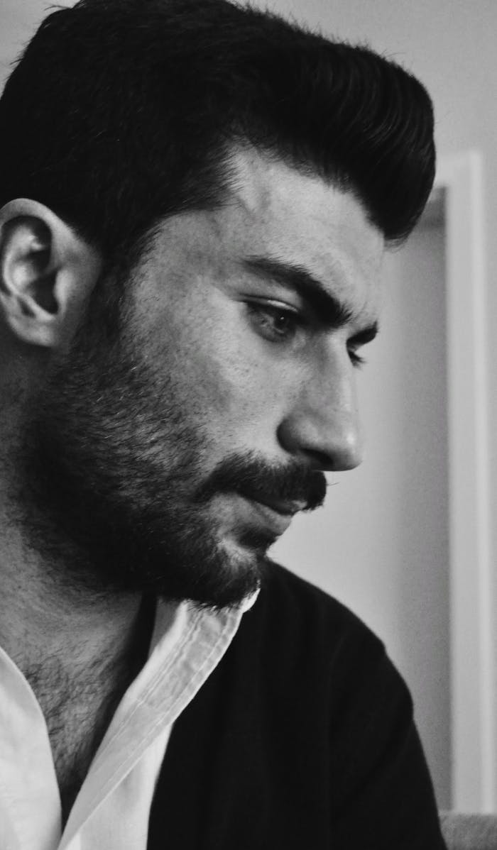 services-03 Introspective black and white portrait of a thoughtful man indoors.