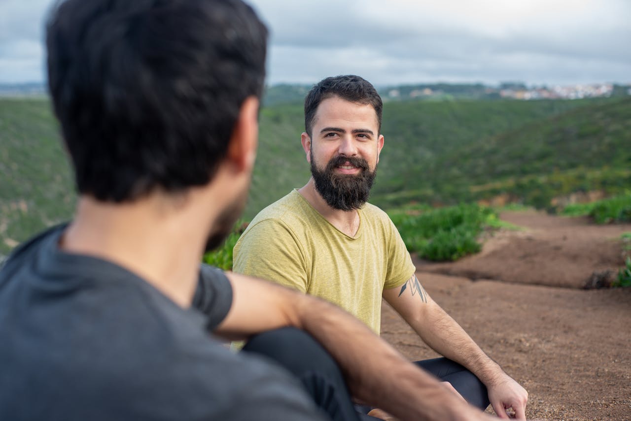 get-in-touch Two men enjoying a tranquil moment outdoors in the lush landscape of Portugal, embracing relaxation and wellbeing.